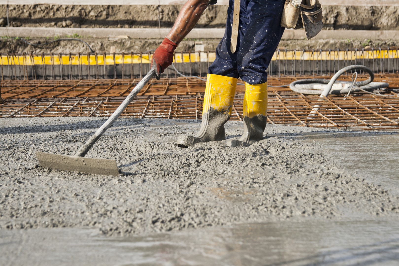 bricklayer at work on a construction site during the laying of concrete to build the foundations of a house