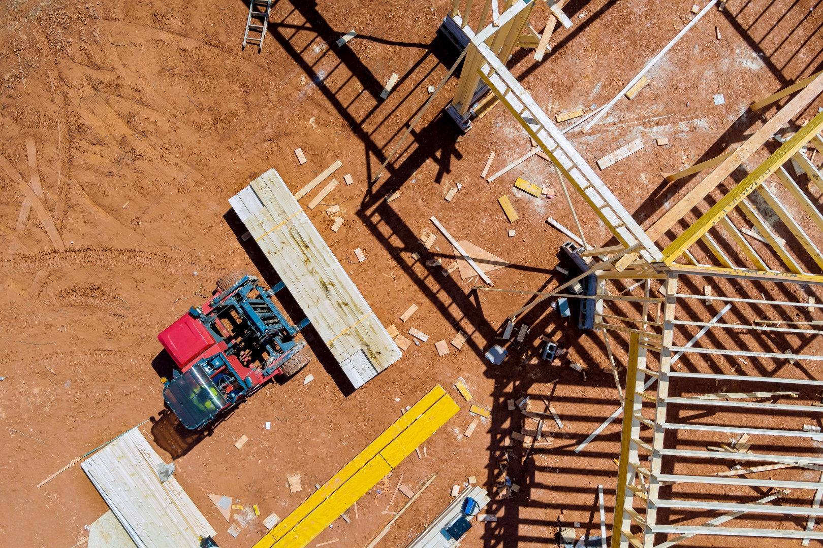 Lift manipulator unloads wooden delivered building material on the construction site